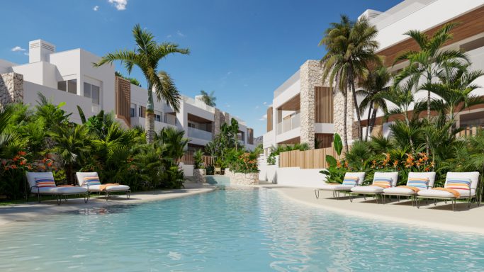 Piscine tranquille entourée de palmiers et de maisons modernes, chaises longues à proximité.