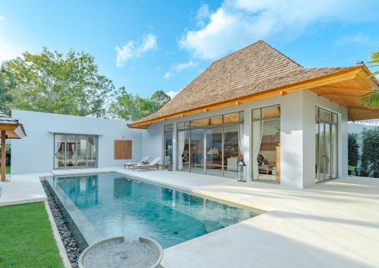 Villa moderne avec piscine, toits en chaume et jardin verdoyant.