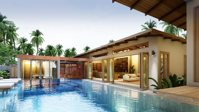 Maison moderne avec piscine, palmiers et espace de vie extérieur confortable.