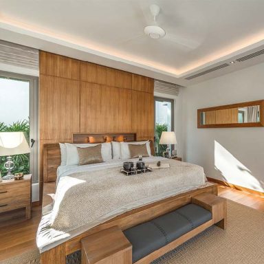 Chambre moderne avec lit king-size, parquet en bois et éclairage chaleureux.